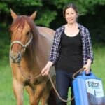 Christin Nydegger mit einem Pferd und einem Koffer in der Hand
