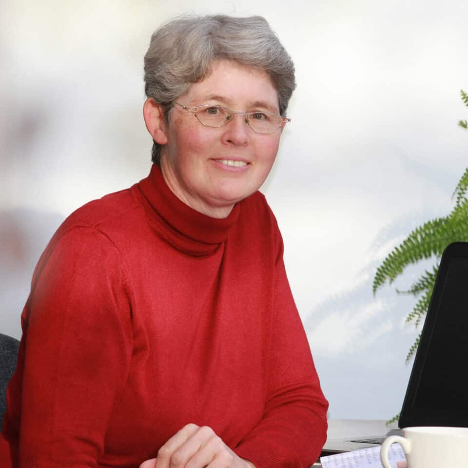 Porträtbild von Claudia Barfuss in rotem Rollkragenpullover.