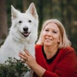 Porträt von Kathrin Steuble mit einem weisen Schäferhund.